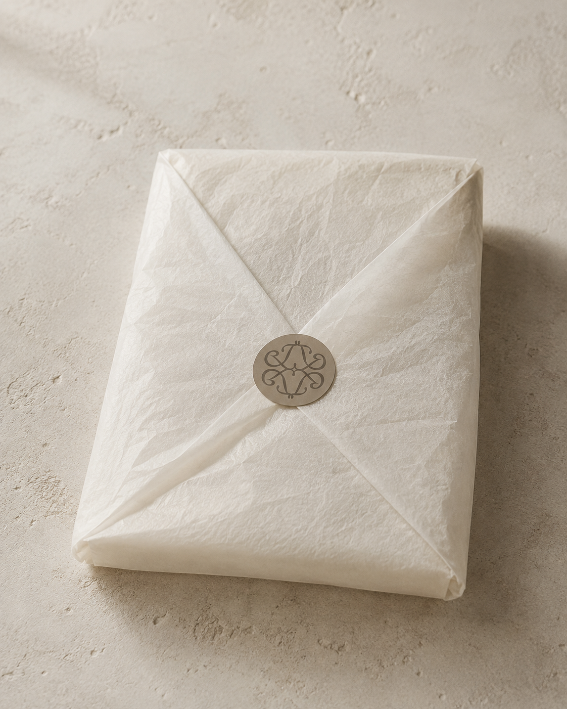 Confezione regalo Exhal in velina avorio chiusa con il simbolo del brand